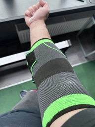 Спортивный бандаж локтевого сустава налокотник с фиксирующим ремнем ортез компрессионный фиксатор на локоть чёрный с зелёным фото от покупателей 3