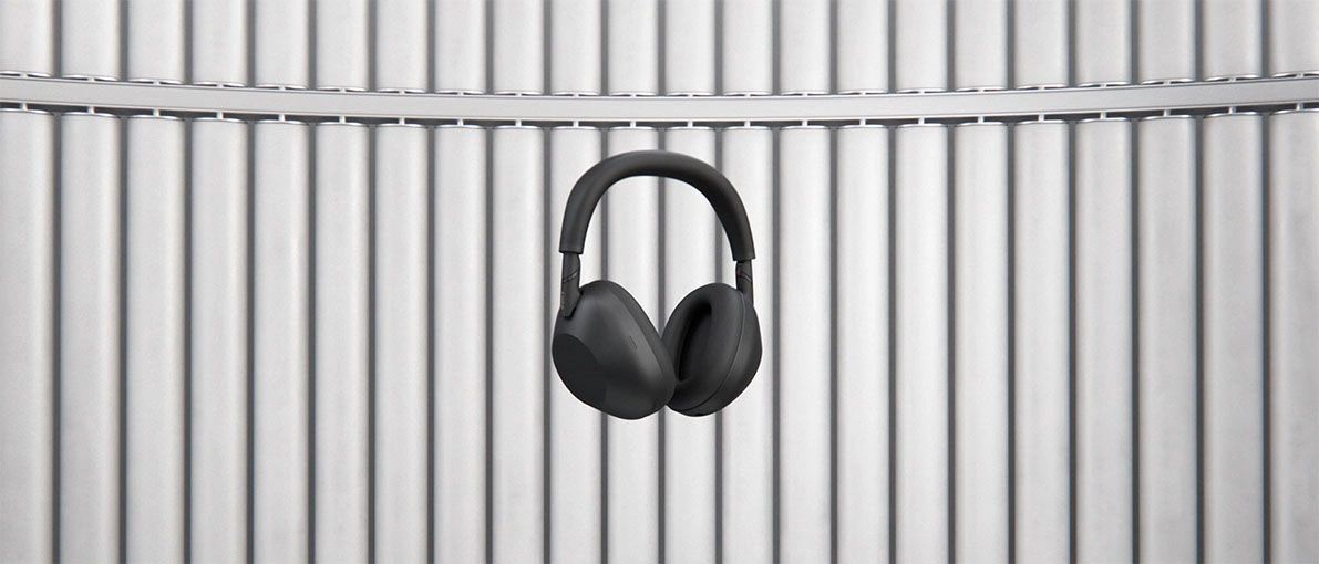 Чёрные беспроводные наушники Sony WH-1000XM6 на фоне ребристой светлой стены