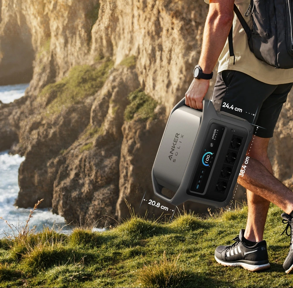 Мужчина несёт зарядную станцию Anker SOLIX C1000 Gen 2 по тропе возле моря