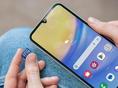 Рука вставляет карту памяти T7 microSD в смартфон