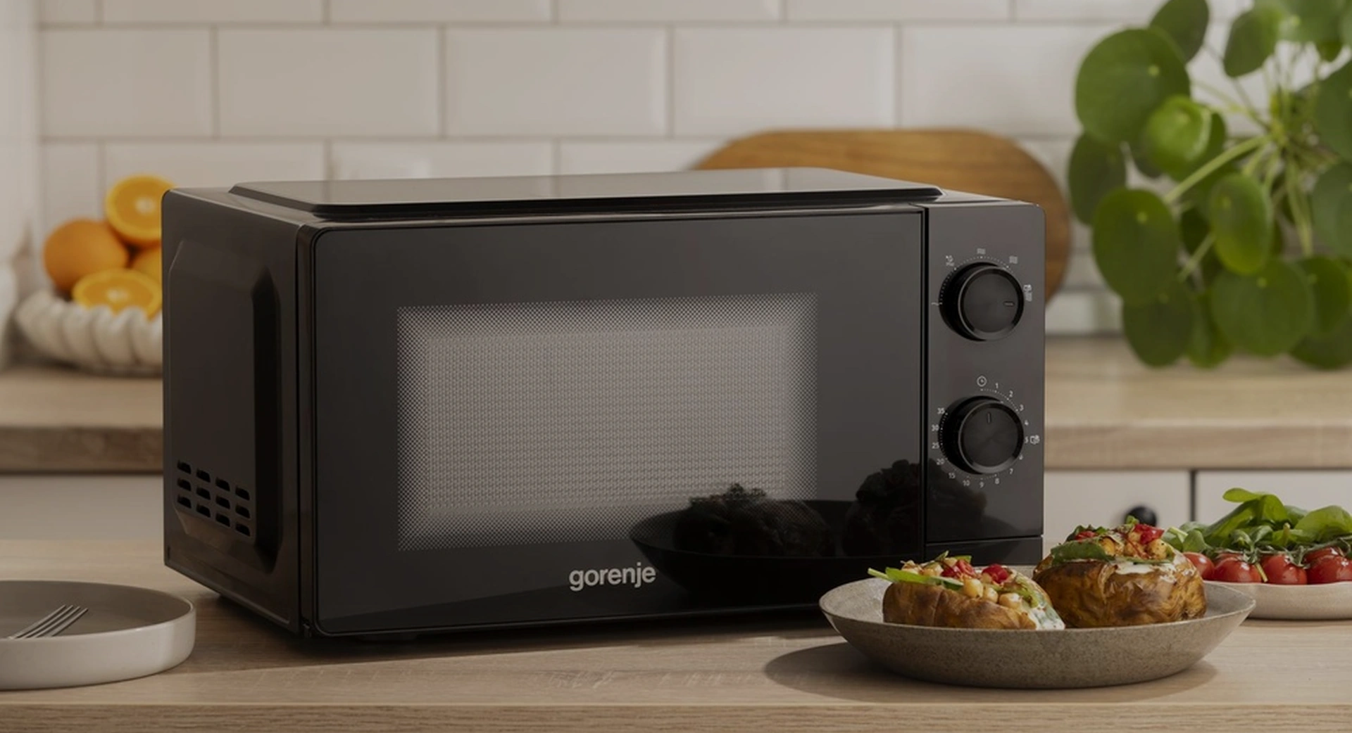 Чёрная микроволновая печь Gorenje MO20CE1B5 на кухонной столешнице