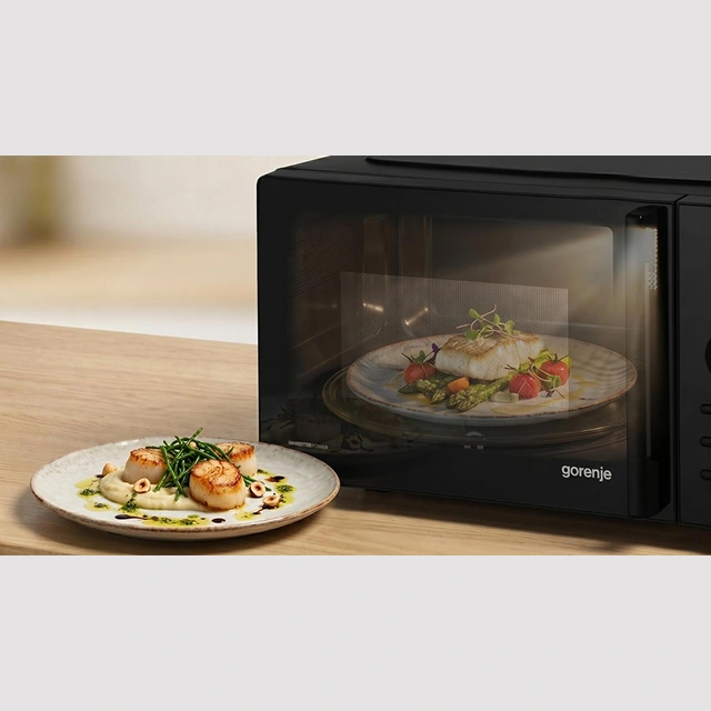 Освещённая камера микроволновой печи Gorenje с блюдом внутри