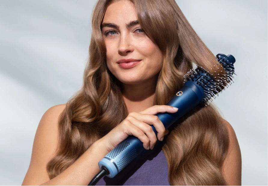 Женщина создаёт объём щёткой мультистайлера Philips