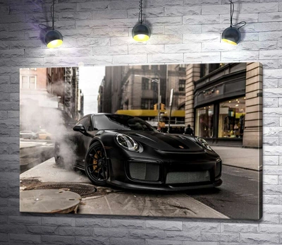 Картина Угольно-черный автомобиль Порше (Porsche) 911 среди улицы старого города 100x67 см Модуль №1 (000178)