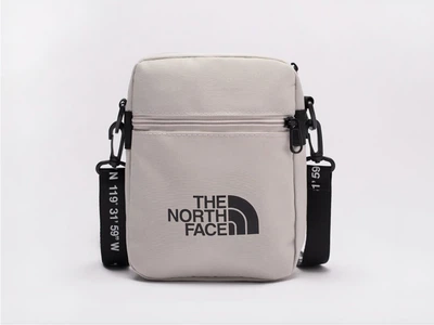 Сумка через плече The North Face з монограмним ремінцем у сірому кольорі.