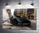 Картина Угольно-черный автомобиль Порше (Porsche) 911 среди улицы старого города 100x67 см Модуль №1 (000178) - изображение 1